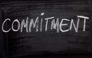 The word Commitment on a Blackboard